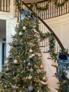 Grand Foyer Tree With Blue Velvet Bows And Garland-Draped Staircase