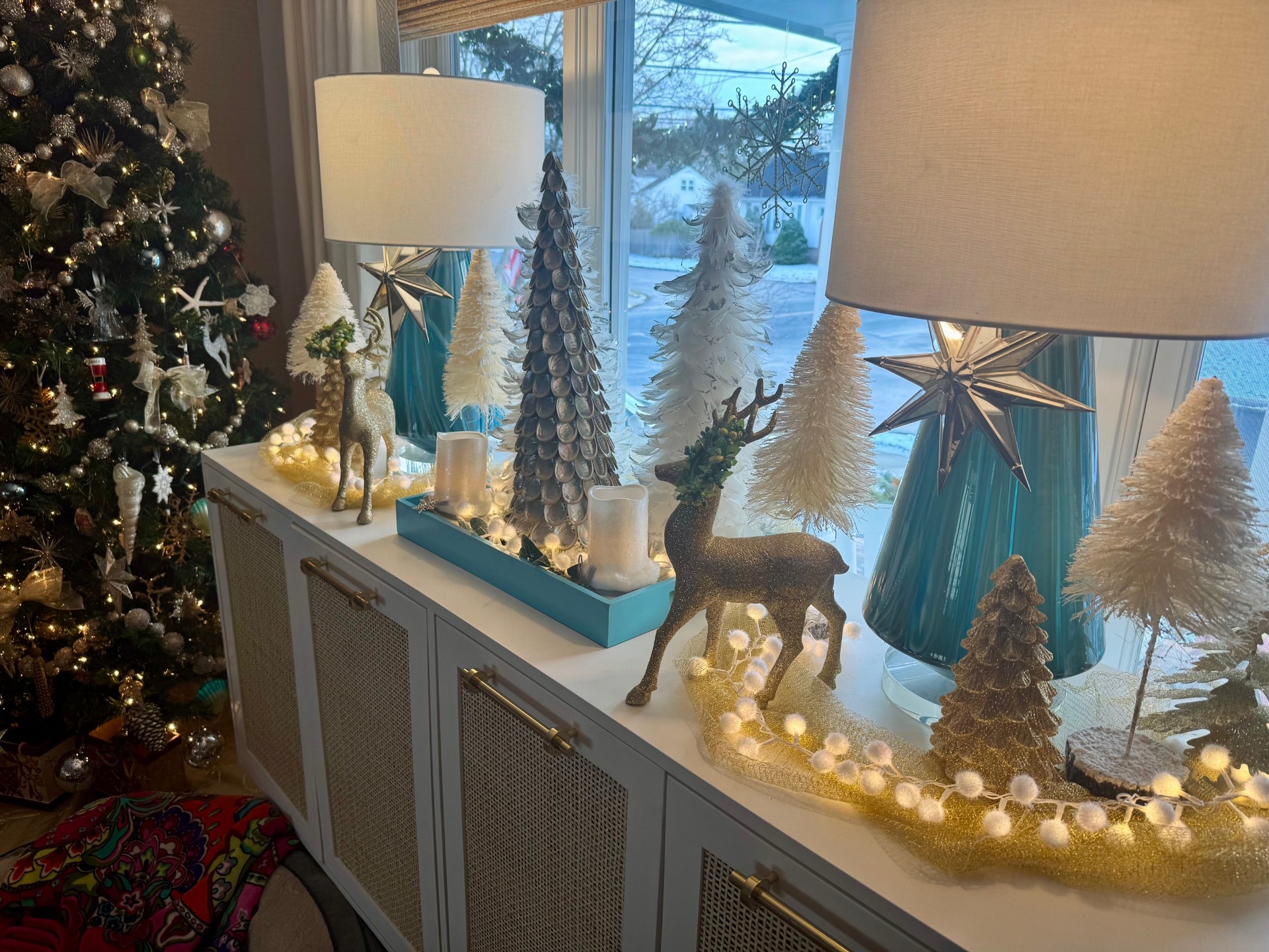 Cozy winter tablescape with greenery, candles, and mixed metallics