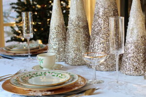 Sparkling Holiday Table With Gold Cone Trees and Festive Dinnerware